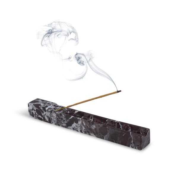 Marble incense holder with a burning incense stick on a white background